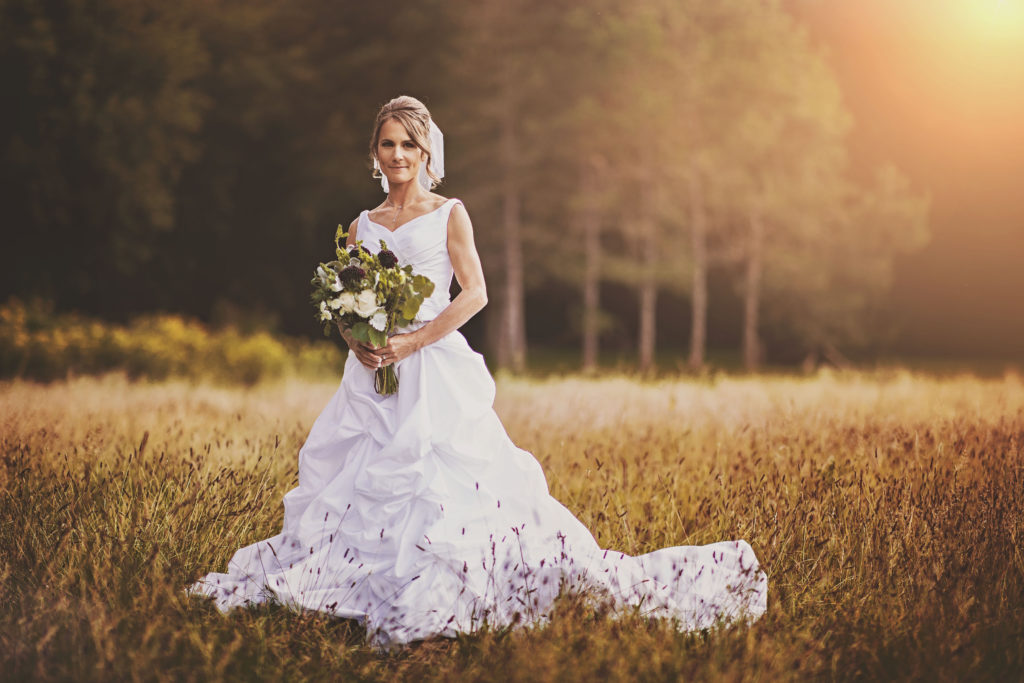 sunset bride formal pose in a field