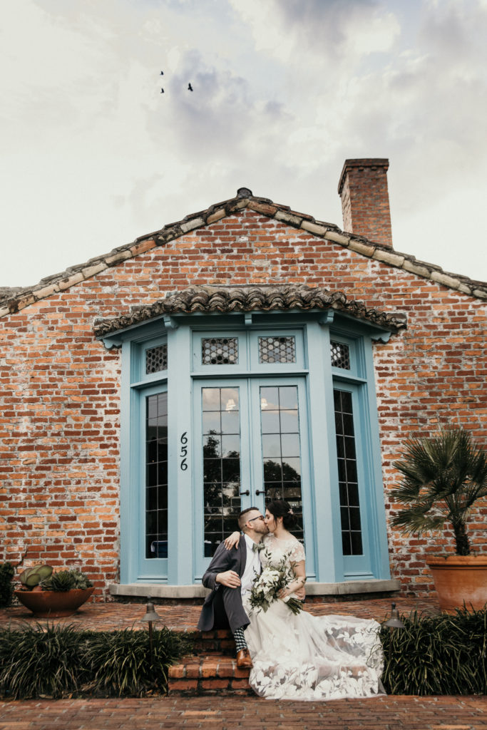 A wedding photograph of the bride and groom kissing on the steps of Casa Feliz, a historic museum and home in this list of Central Florida wedding venues